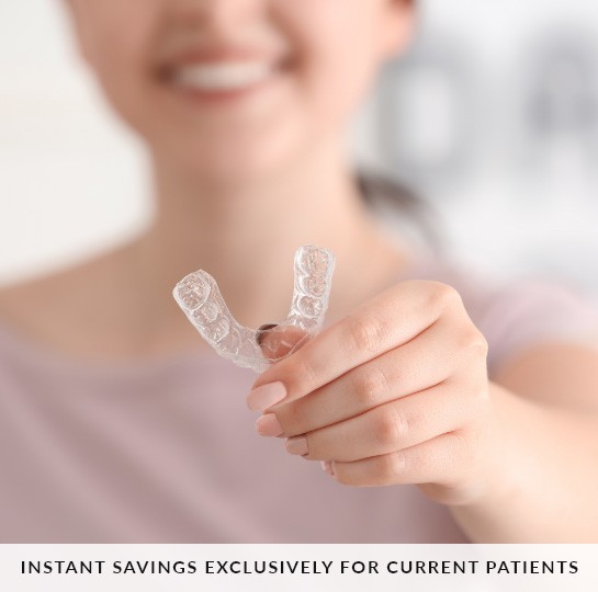 Woman holding a Clear Aligner with text 'Instant Savings Exlusively for Current Patients'